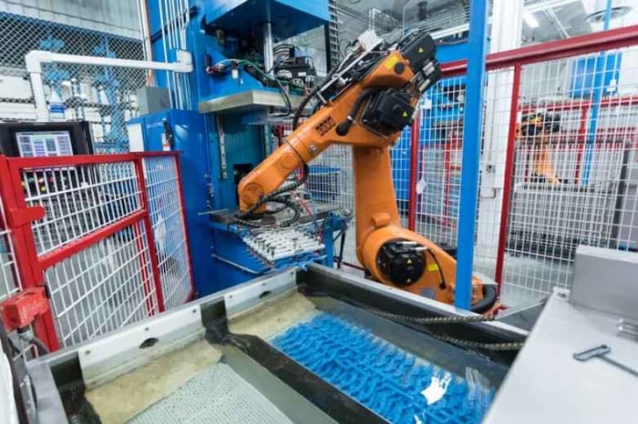 Automated machine dropping molded parts into a kiln
